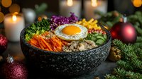 Festive bibimbap bowl with sunny side up egg, colorful vegetables, and mushrooms served in stone bowl against Christmas decorations and warm candlelight background.