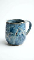Handmade ceramic mug with blue glaze and rustic texture, isolated on white background. Perfect for home decor, tableware design, and product photography.