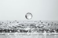 Water droplet creating ripples and splash with crystal clear details captured in high-speed photography showing dynamic motion and fluid dynamics.