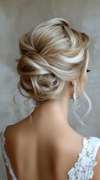 Elegant blonde updo hairstyle with loose tendrils, showcasing diamond earrings and lace wedding dress detail against neutral background.