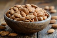 Fresh whole almonds in rustic wooden bowl on dark wooden table background, selective focus on nuts, natural healthy snack for vegetarian diet.