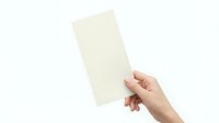 Hand holding blank cream colored paper sheet on white background isolated for mockup design and presentation templates.