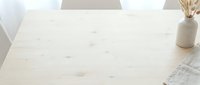 Minimalist workspace with light wooden desk, dried pampas grass in ceramic vase, and architectural blueprints, ideal for interior design and office decor projects.