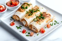 Grilled chicken burritos with melted cheese, wrapped in flour tortillas, garnished with fresh parsley and diced tomatoes, served on white plate.