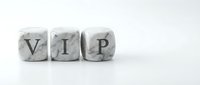 White marble dice spelling VIP letters on clean background for luxury branding and exclusive membership concepts.