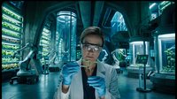 Female scientist examining test tube in futuristic laboratory with advanced equipment and blue lighting for research and development projects.
