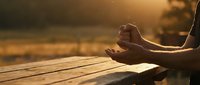 Close-up of hands in meditation mudra position during golden hour sunset, peaceful mindfulness practice for wellness and spiritual balance concepts.