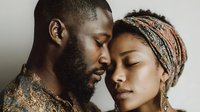Intimate African American couple sharing tender moment with foreheads touching, expressing love and connection in warm natural lighting for relationship content.