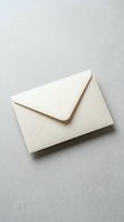 Cream colored envelope on neutral gray background for correspondence, invitations, and business communications.