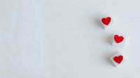 Three red hearts arranged vertically on white background with copy space for romantic designs and Valentine's Day projects.