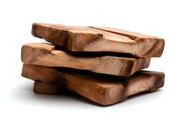Stacked chunks of milk chocolate pieces on white background, showing texture and layers of fresh confectionery. Macro food photography with soft shadows.
