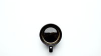 Black coffee cup with dark espresso on white background, isolated for design projects and commercial use.