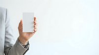 Caucasian male hand holding blank white card against neutral background for business branding, marketing mockup, or corporate identity presentation.
