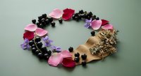 Colorful flower petals arranged in heart shape with coffee beans and golden decorative elements on neutral background for romantic design projects.