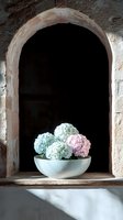 Pastel hydrangea flowers in white ceramic bowl placed in stone arch alcove with dramatic lighting and shadows creating moody atmospheric composition.