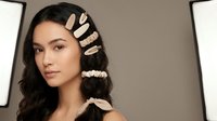 Young Hispanic woman with trendy hair clips and accessories posing in professional studio lighting setup for beauty and fashion photography.