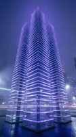 Illuminated modern skyscraper with purple neon lighting and geometric chevron facade design at night, suitable for urban architecture, technology, and corporate branding projects.
