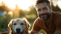 Happy middle-aged Caucasian man with beard smiling while bonding with golden retriever dog outdoors during golden hour sunset in backyard garden setting.