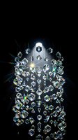 Luxury crystal chandelier with sparkling diamonds creating rainbow light reflections on black background for elegant interior design projects.