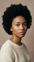 Young African American woman with natural afro hairstyle wearing cream sweater against neutral background for beauty and lifestyle concepts.