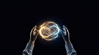 Hands holding glowing wireframe globe with golden and blue light effects against dark background, representing global technology, innovation, and digital connectivity for business concepts.