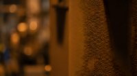 Warm golden bokeh lights create atmospheric depth behind textured brown surface in cozy interior setting for backgrounds and design projects.