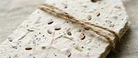 Handmade paper with embedded seeds and twine binding, ready for eco-friendly stationery, invitations, and sustainable packaging design projects.