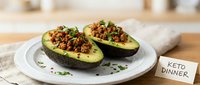 Stuffed avocado halves topped with seasoned ground meat and vegetables served on white plate for keto dinner meal prep and low-carb eating.