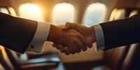 Business handshake between executives in airplane cabin with warm lighting through windows, symbolizing partnership and successful deal closing.