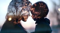 Romantic double exposure silhouette of young couple in love against sunset sky with tree branches creating dreamy atmospheric mood. Perfect for valentines designs.