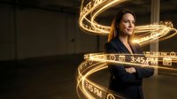 Young woman with dark hair and light skin tone, wearing dark business attire, surrounded by glowing golden light trails and digital time displays, representing technology, innovation, and time management for corporate and digital design projects.