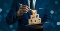 Professional businessman in suit stacking wooden blocks with business icons on tablet, representing strategic planning and corporate growth solutions.