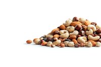 Mixed raw nuts and seeds pile including cashews, almonds, hazelnuts on white isolated background. Healthy protein-rich snack food concept.
