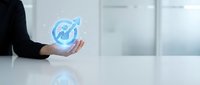 Businessperson holding glowing upward arrow chart icon symbolizing growth, success, and financial progress in corporate environment.