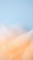 Soft pastel clouds in dreamy sky with gentle orange pink and blue gradient colors creating peaceful atmospheric background for meditation wellness.