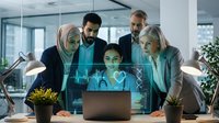 Diverse business team collaborating on futuristic technology project with holographic data visualization in modern office environment.