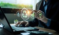 Businessman working on laptop with glowing environmental sustainability icons including recycling, water drop, heart and lightbulb in modern office.