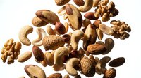 Mixed nuts and seeds collection with almonds walnuts cashews brazil nuts hazelnuts isolated on white background for healthy snacking and cooking recipes.