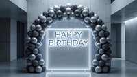 Glowing Happy Birthday neon sign framed by silver and gray balloon arch in a modern concrete interior for party decor.