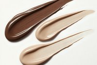 Cosmetic foundation swatches in different skin tones from dark to light on white background, showing creamy texture and smooth consistency for makeup and beauty.