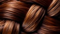 Luxurious brown hair braid macro shot showing glossy, healthy strands with copper and caramel highlights intertwined in detailed texture pattern.