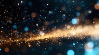Magical glowing particles with blue and gold bokeh effect on dark background create atmospheric festive mood for holiday designs and celebrations.