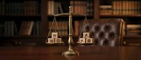 Wooden blocks spelling LEGAL balanced on brass scales of justice in lawyer office with law books and leather chair background for legal services.