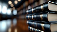 Stack of leather-bound books with gold embossing on dark wooden surface against blurred bokeh background, creating scholarly atmosphere for education and literature concepts.