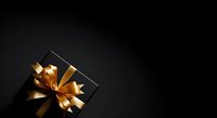 Luxury black gift box with golden ribbon bow on dark background, perfect for holiday, celebration, and premium product packaging designs.