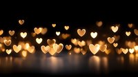 Romantic golden heart-shaped bokeh lights creating warm atmospheric glow against dark background for Valentine's Day, wedding, anniversary celebrations and love themes.