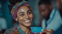 Young African woman with colorful headwrap smiling warmly in professional healthcare setting with medical team background for diversity campaigns.
