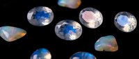 Collection of sparkling faceted gemstones with rainbow reflections on black background for jewelry design and luxury accessories projects.