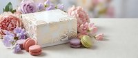 Elegant gift box with colorful macarons and fresh flowers arrangement for special occasions, celebrations, birthdays, weddings or romantic events.
