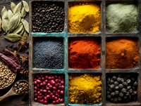 Colorful assortment of spices in wooden compartment box with turmeric, paprika, pepper, bay leaves and star anise for cooking and seasoning.